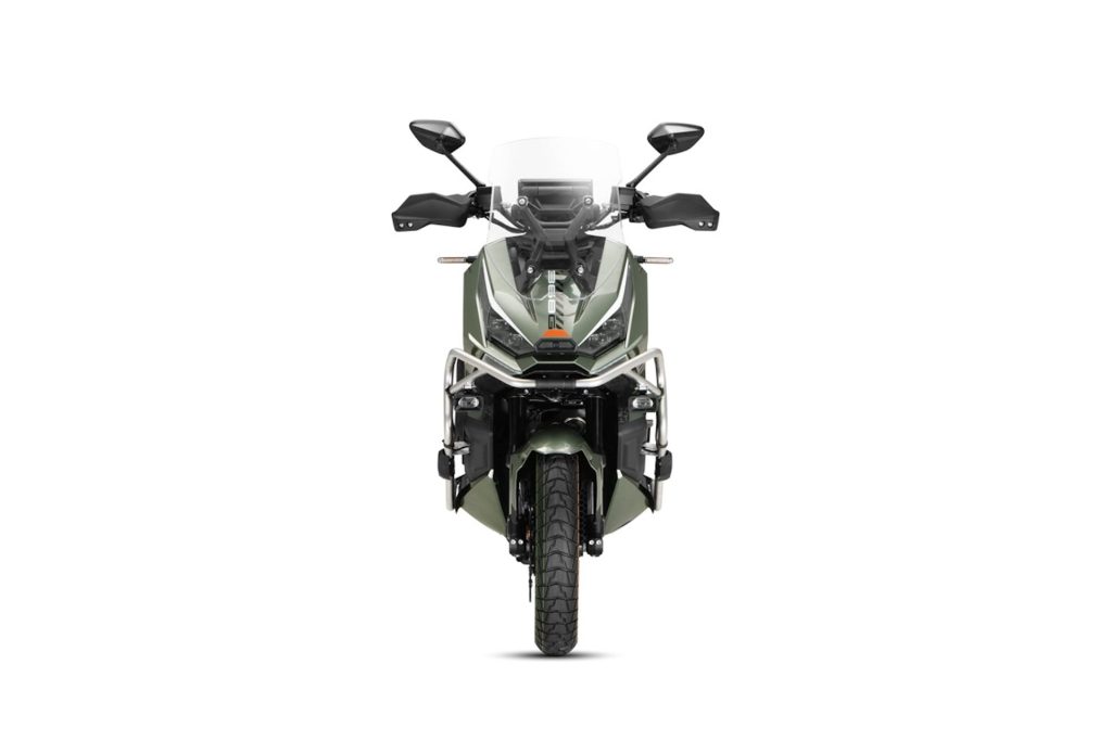 Front view of an olive-green adventure motorcycle with a windscreen, dual headlights, and protective crash bars.